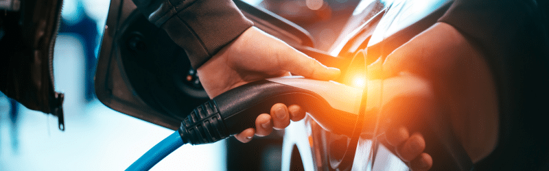 Persona cargando coche eléctrico